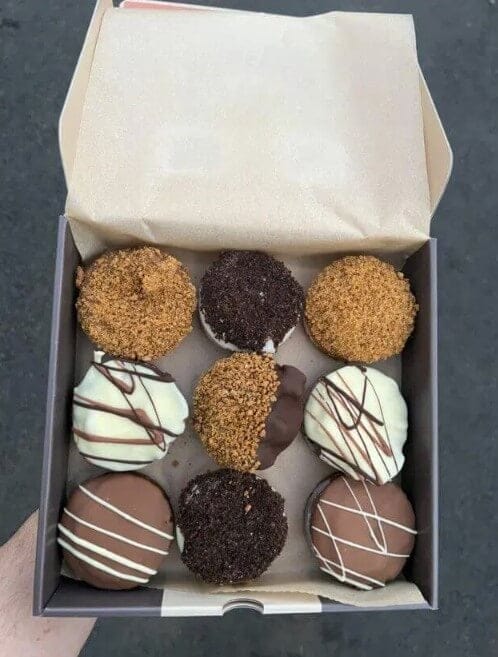 image shows a box of bronwies, some imperfectly shaped with delicious looking toppings